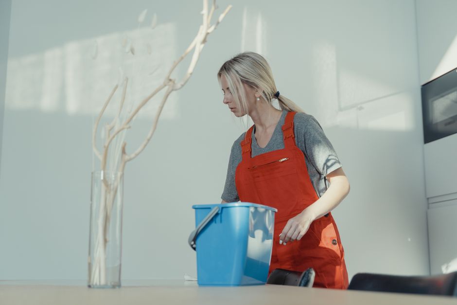 A friendly, professional cleaner organizing a residential space